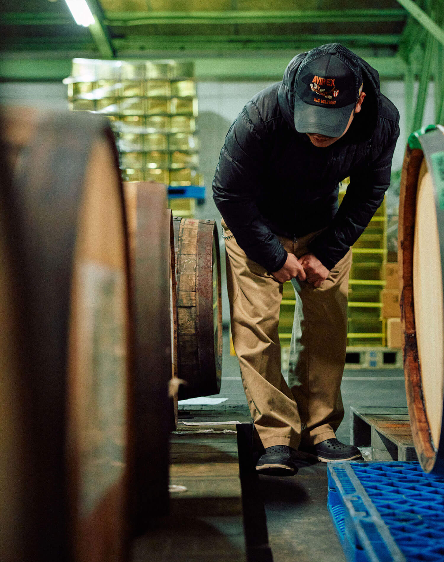 熟成庫で樽と向き合う中野料理長